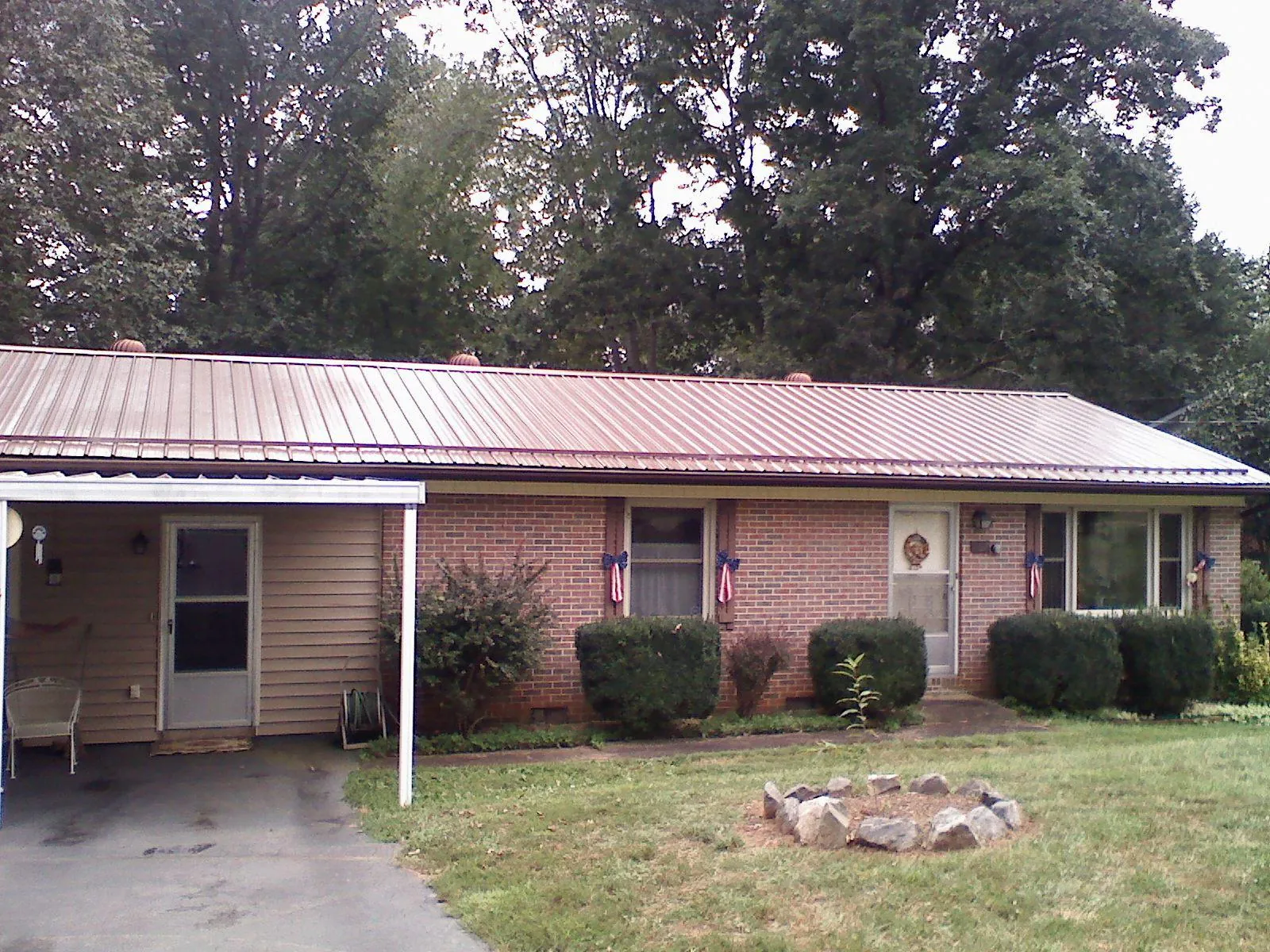 Bronze metal roof and carport on a brick ranch home — Roof Repair work by our crew in Hudsonville
